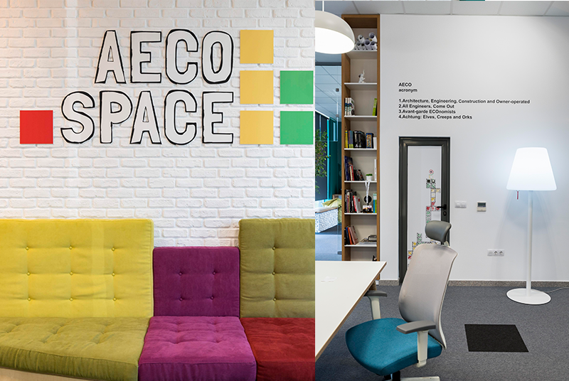 The AECO Space logo on white brick wall and colorful sofa.